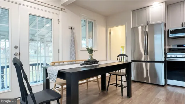 a kitchen with stainless steel appliances a table chairs and a refrigerator