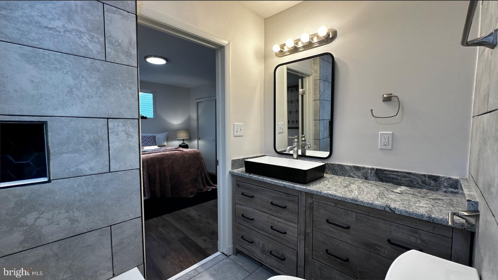 8802 Ashford Road Parkville, MD 21234 - Photo 14 of 39 a en suite bathroom with a granite countertop sink and a mirror