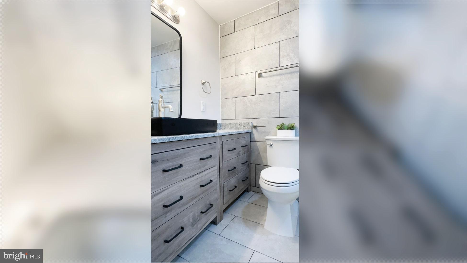 8802 Ashford Road Parkville, MD 21234 - Photo 15 of 39 a bathroom with a toilet a sink and mirror