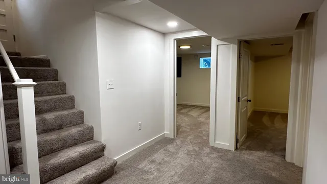 an empty room with wooden floor and a hallway