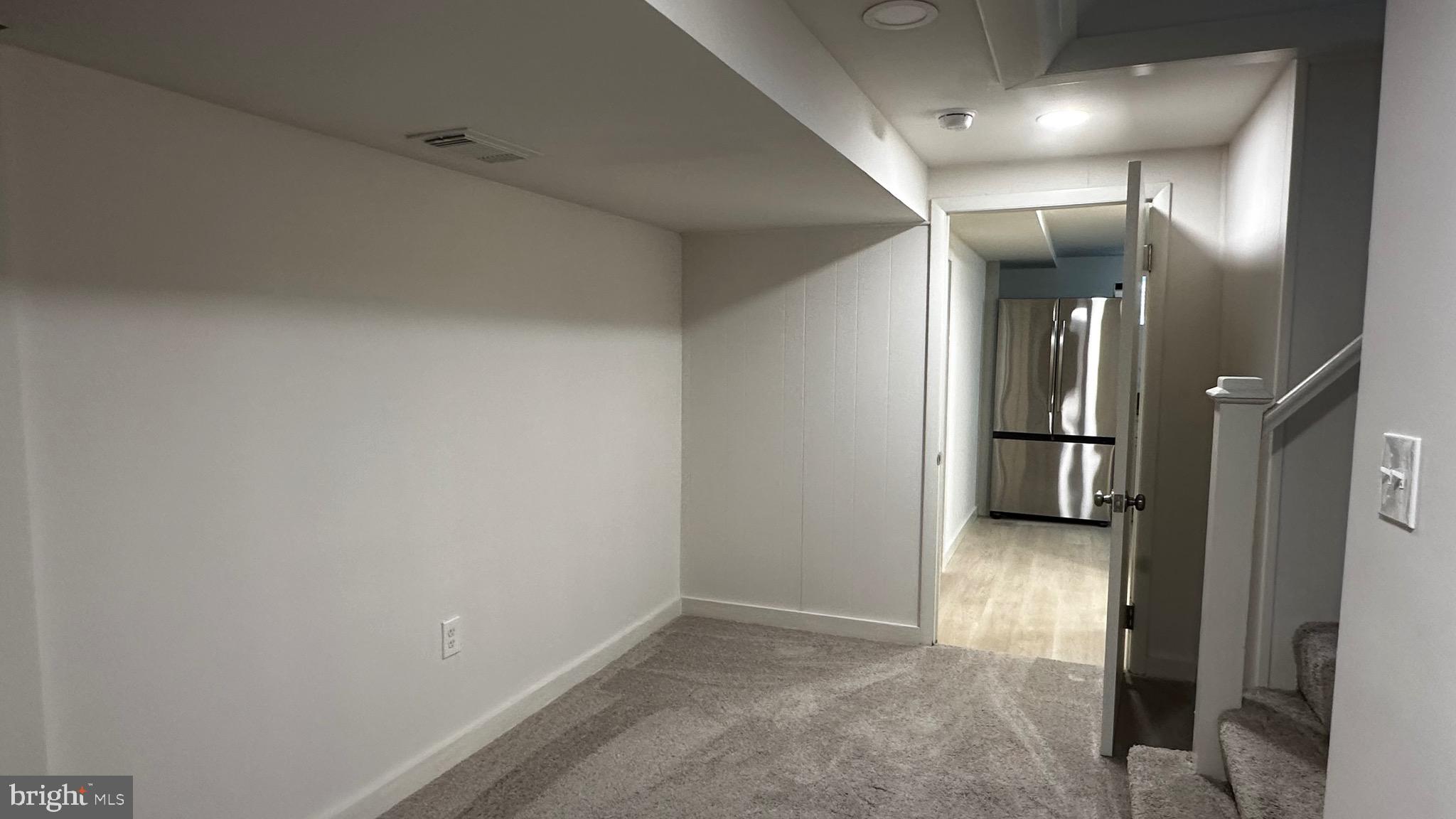 8802 Ashford Road Parkville, MD 21234 - Photo 36 of 39 an empty room with wooden floor and a hallway