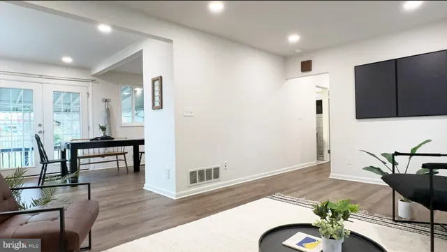 a living room with furniture and a wooden floor