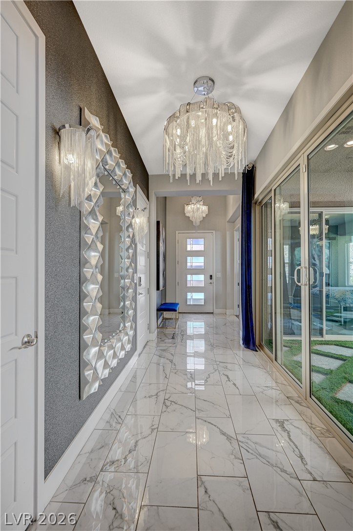 3943 Reyes Avenue Las Vegas, NV 89141 - Photo 21 of 95 A lavish hallway showcases sleek tiled flooring and sparkling modern light fixtures.