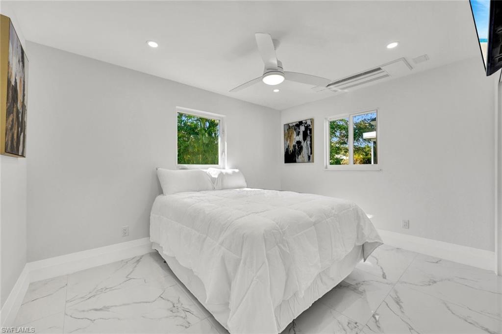 20 Kings Road, Unit A18 Naples, FL 34112 - Photo 14 of 19 a bedroom with a large bed and a window