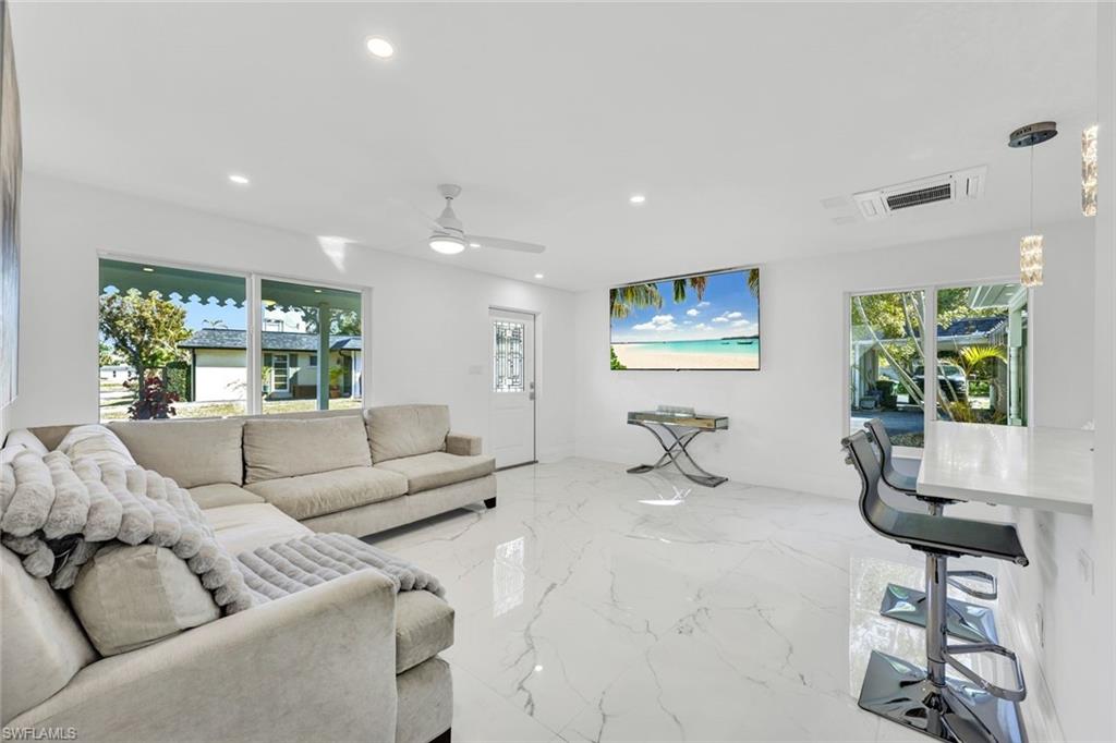 20 Kings Road, Unit A18 Naples, FL 34112 - Photo 4 of 19 a living room with furniture and a large window