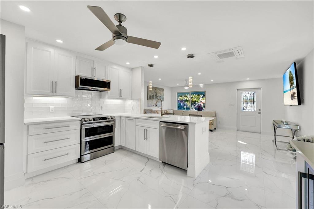 20 Kings Road, Unit A18 Naples, FL 34112 - Photo 8 of 19 a kitchen with stainless steel appliances kitchen island granite countertop a stove and a sink