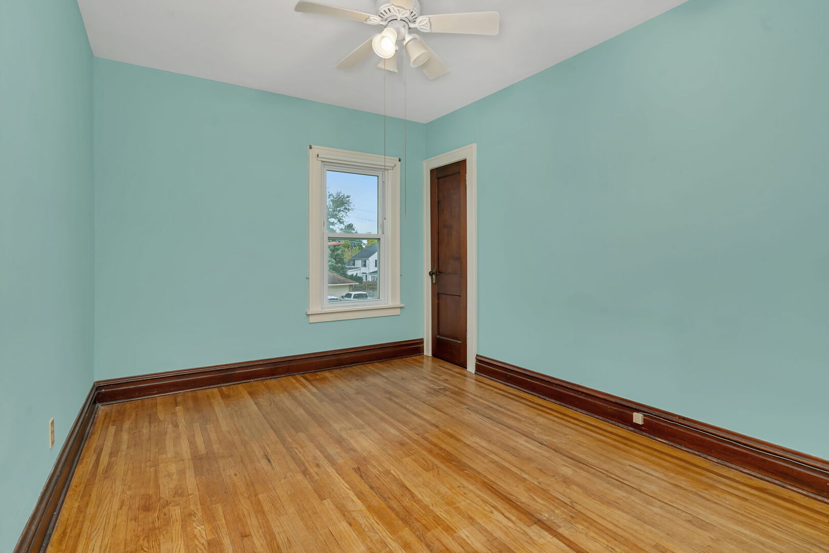 1105 Taylor Street Joliet, IL 60435 - Photo 14 of 24 an empty room with wooden floor chandelier fan and windows