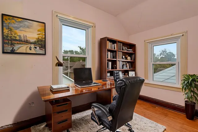 a view of a workspace with furniture and a window