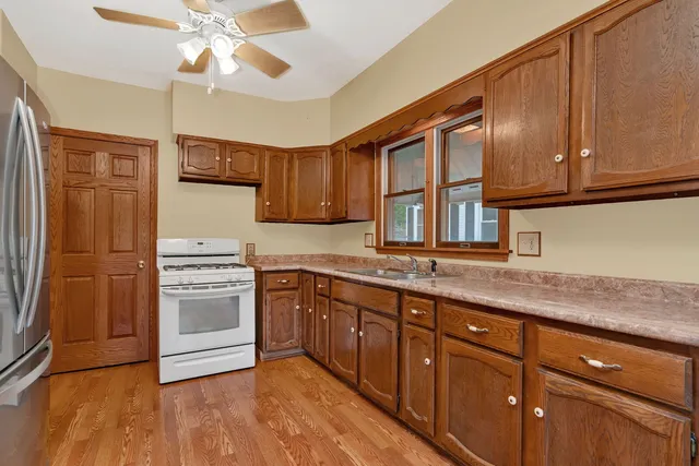 a kitchen with stainless steel appliances granite countertop a sink a stove and a refrigerator