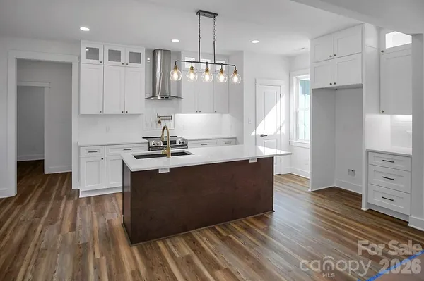 a kitchen with granite countertop a sink cabinets and wooden floor