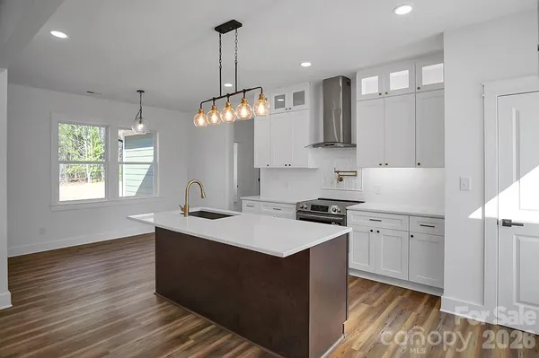 a kitchen with a sink and wooden floor