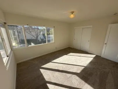 a view of a bedroom with wooden floor and windows