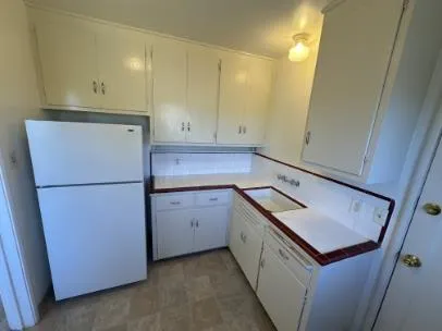 a kitchen with a refrigerator sink and cabinets