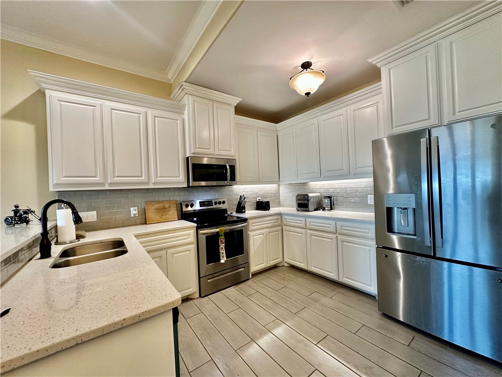 5434 Neela Corpus Christi, TX 78413 - Photo 11 of 31 a kitchen with stainless steel appliances granite countertop a refrigerator sink and white cabinets