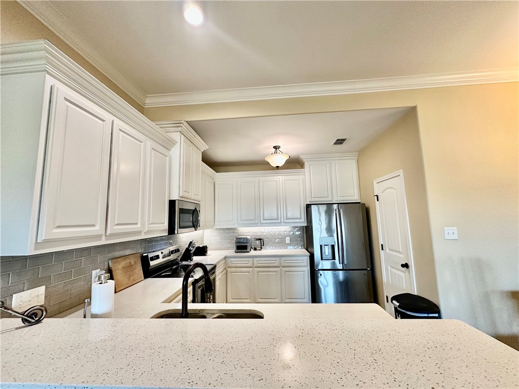 5434 Neela Corpus Christi, TX 78413 - Photo 12 of 31 a kitchen with stainless steel appliances kitchen island a refrigerator sink and cabinets