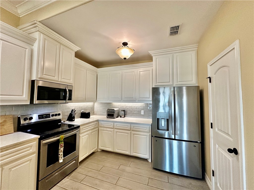5434 Neela Corpus Christi, TX 78413 - Photo 13 of 31 a kitchen with stainless steel appliances a refrigerator sink and white cabinets
