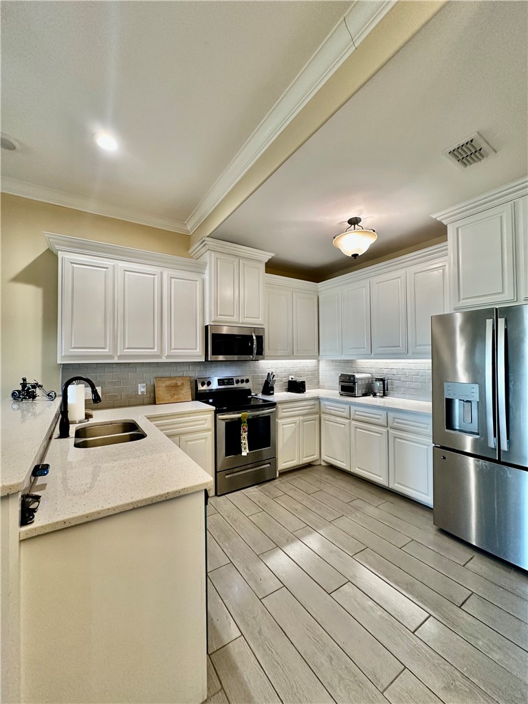 5434 Neela Corpus Christi, TX 78413 - Photo 14 of 31 a kitchen with stainless steel appliances and white cabinets