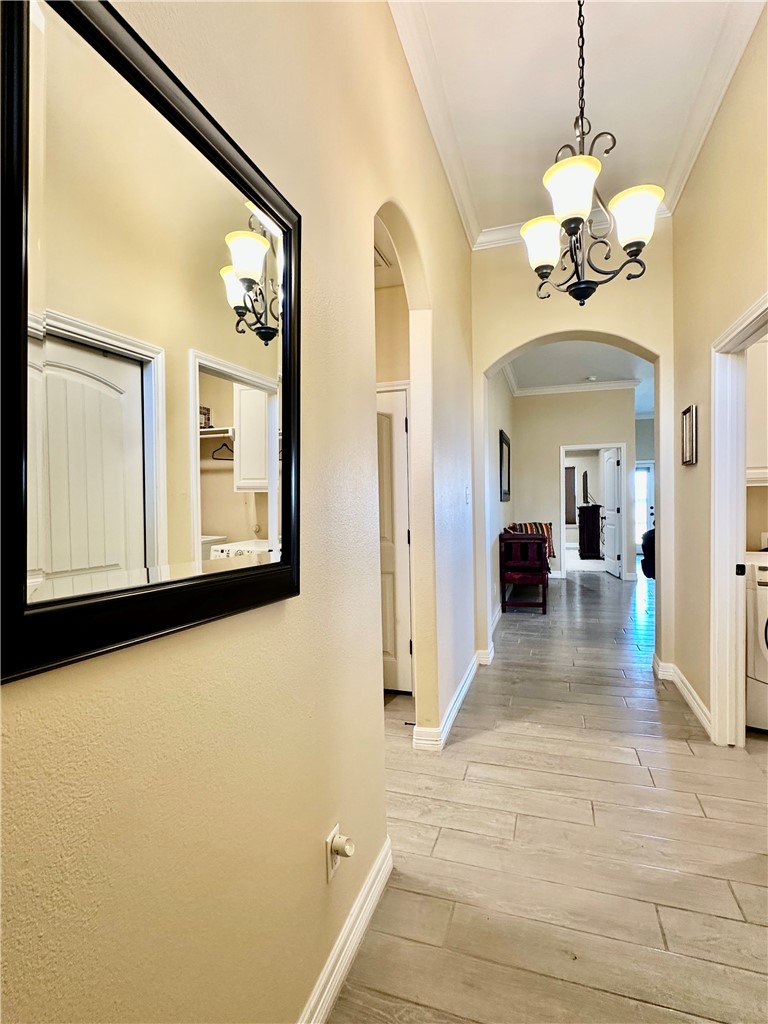 5434 Neela Corpus Christi, TX 78413 - Photo 2 of 31 a view of a hallway with wooden floor and a chandelier