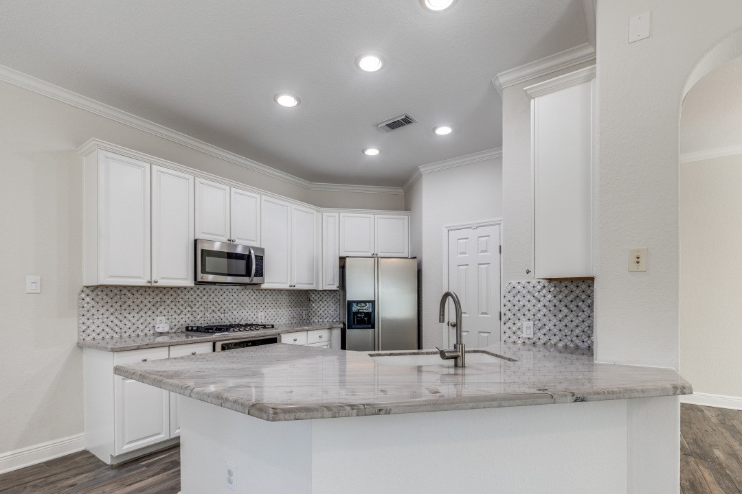 130 South Veranda Ridge Drive Spring, TX 77382 - Photo 7 of 23 a kitchen with kitchen island granite countertop a sink a stove and refrigerator