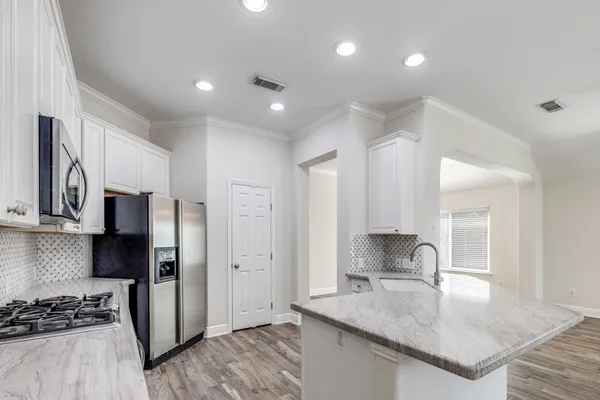 a kitchen with stainless steel appliances granite countertop a sink stove and refrigerator