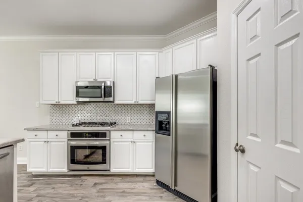 a kitchen with white cabinets and stainless steel appliances