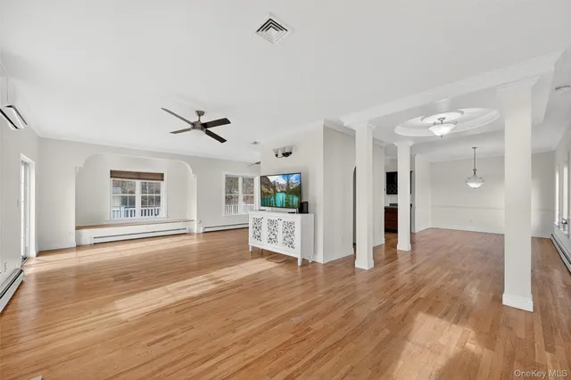 a view of a livingroom with wooden floor and a ceiling fan