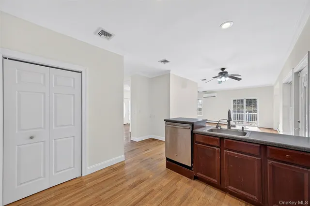 a view of a kitchen counter space a sink wooden floor and a window