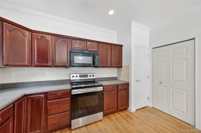 a kitchen with stainless steel appliances granite countertop a stove a sink and a microwave