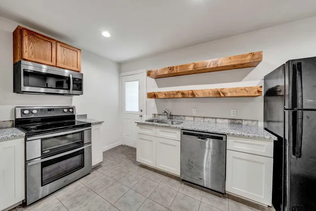 a stove top oven sitting inside of a kitchen