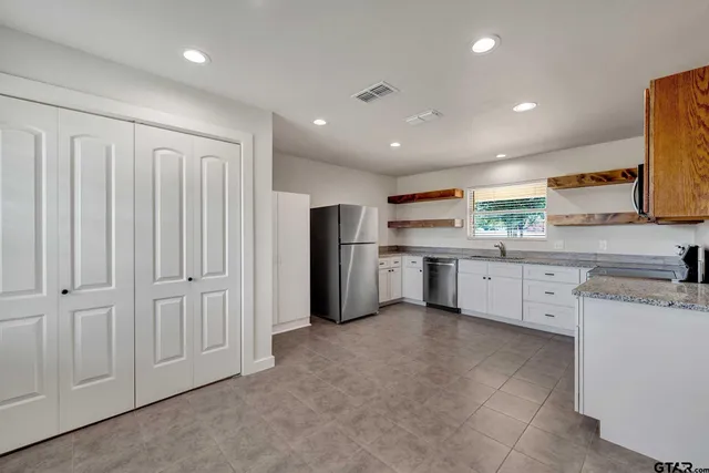 a kitchen with cabinets appliances a sink and a window