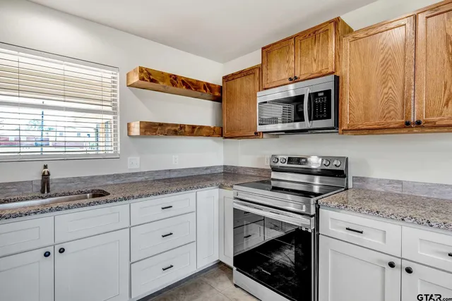 a kitchen with granite countertop cabinets and window