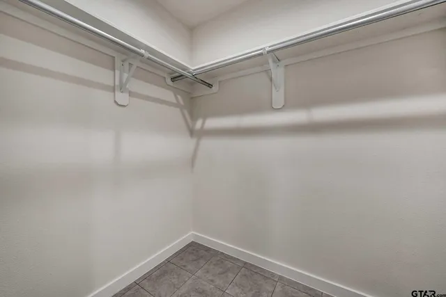 a view of a livingroom with a ceiling fan & windows