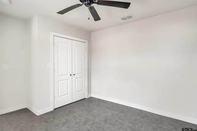 an empty room with a window and a fan