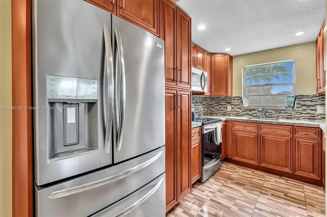 a kitchen with stainless steel appliances granite countertop a refrigerator and a sink