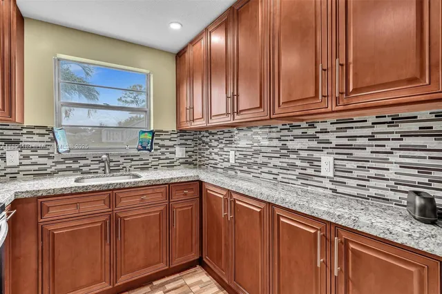 a kitchen with stainless steel appliances granite countertop cabinets and window