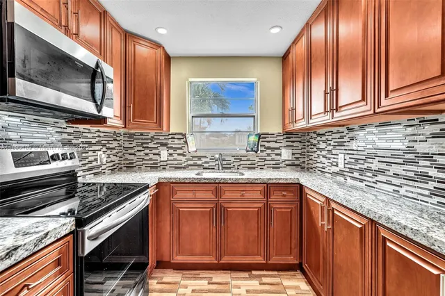 a kitchen with stainless steel appliances granite countertop a sink stove and cabinets