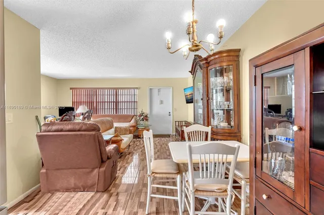 a living room with furniture a chandelier and a dining table