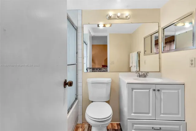 a bathroom with a toilet a sink a mirror and vanity