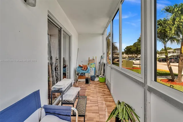 a balcony with chairs and potted plants