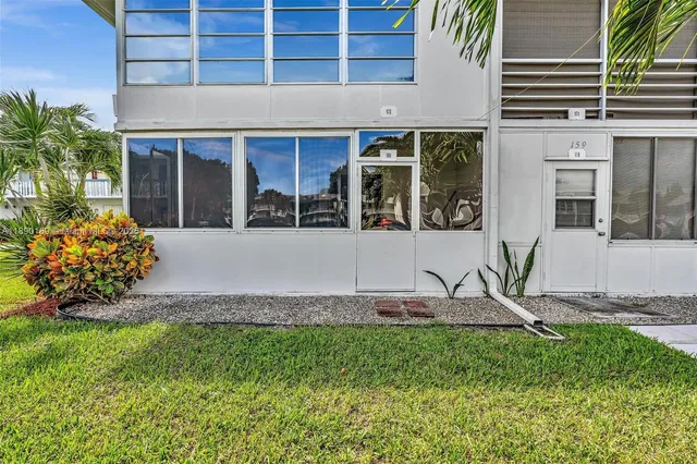 a front view of a house with a garden and plants