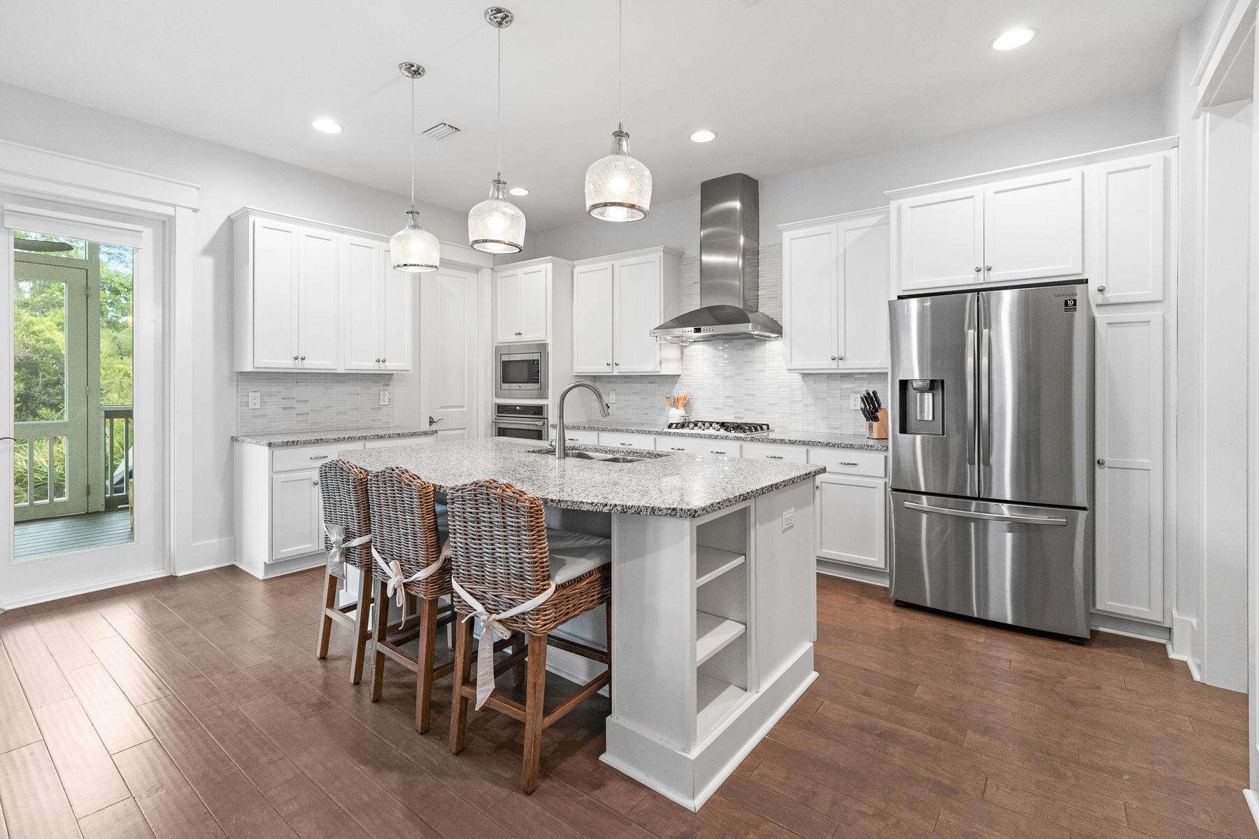 35 Flatwoods Forest Loop Santa Rosa Beach, FL 32459 - Photo 15 of 52 a kitchen with kitchen island granite countertop stainless steel appliances a refrigerator a stove a dining table and chairs