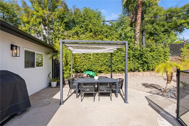 a view of a patio with table and chairs and potted plants