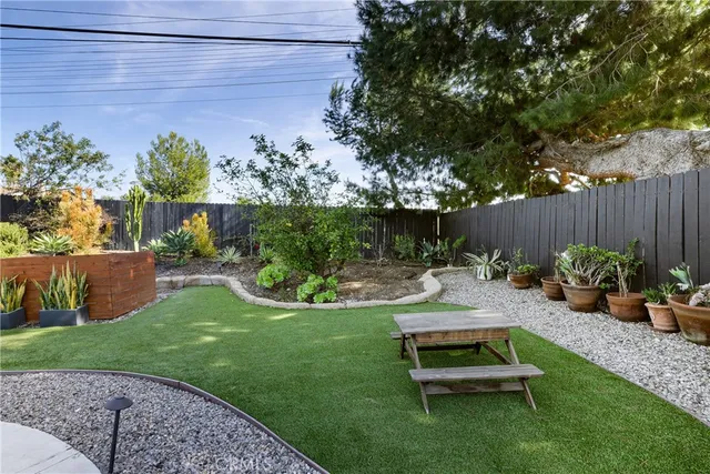 a view of a backyard with couches plants and large tree