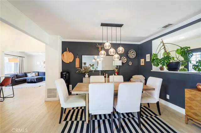 a view of a dining room with furniture a chandelier and wooden floor