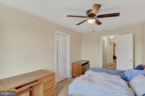 a bedroom with a bed and a ceiling fan