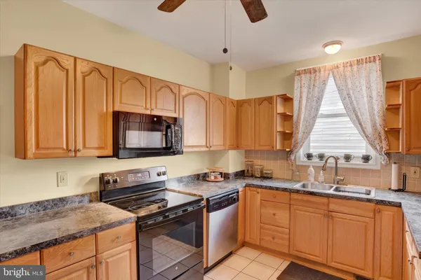 a kitchen with stainless steel appliances granite countertop a stove a sink dishwasher and a microwave oven with cabinets
