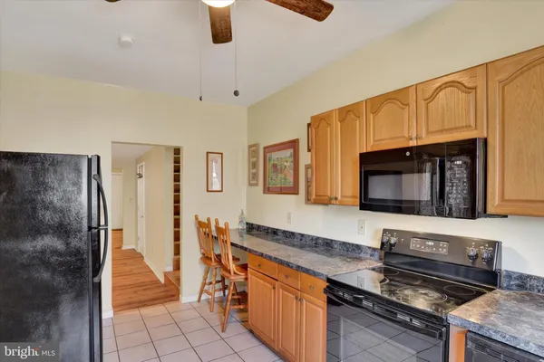 a kitchen with stainless steel appliances kitchen island granite countertop a stove a sink and a microwave