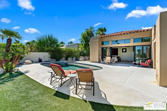 a view of a house with swimming pool and sitting area