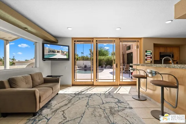 a living room with furniture and a floor to ceiling window