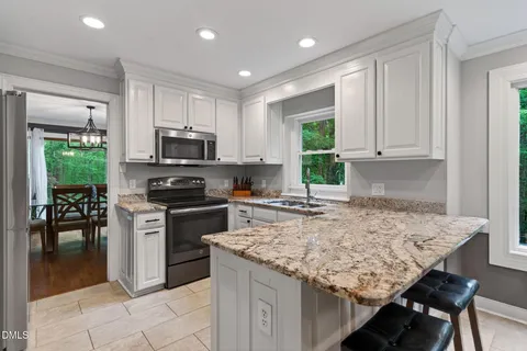 a kitchen with stainless steel appliances granite countertop a refrigerator and a sink